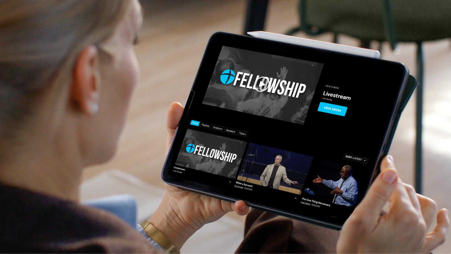 Woman holding a tablet, browsing Fellowship Missionary Church's website