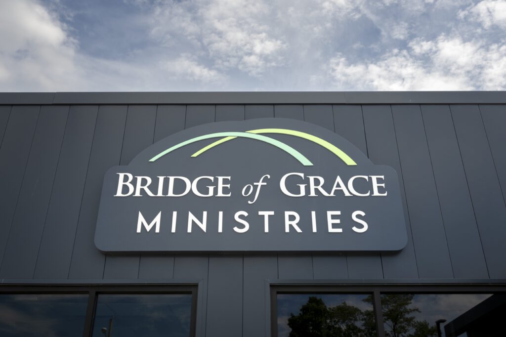 A sign on a building reading Bridge of Grace Ministries